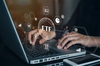 Person working on computer on the ETF exchange traded fund; learn about the best fintech ETFs